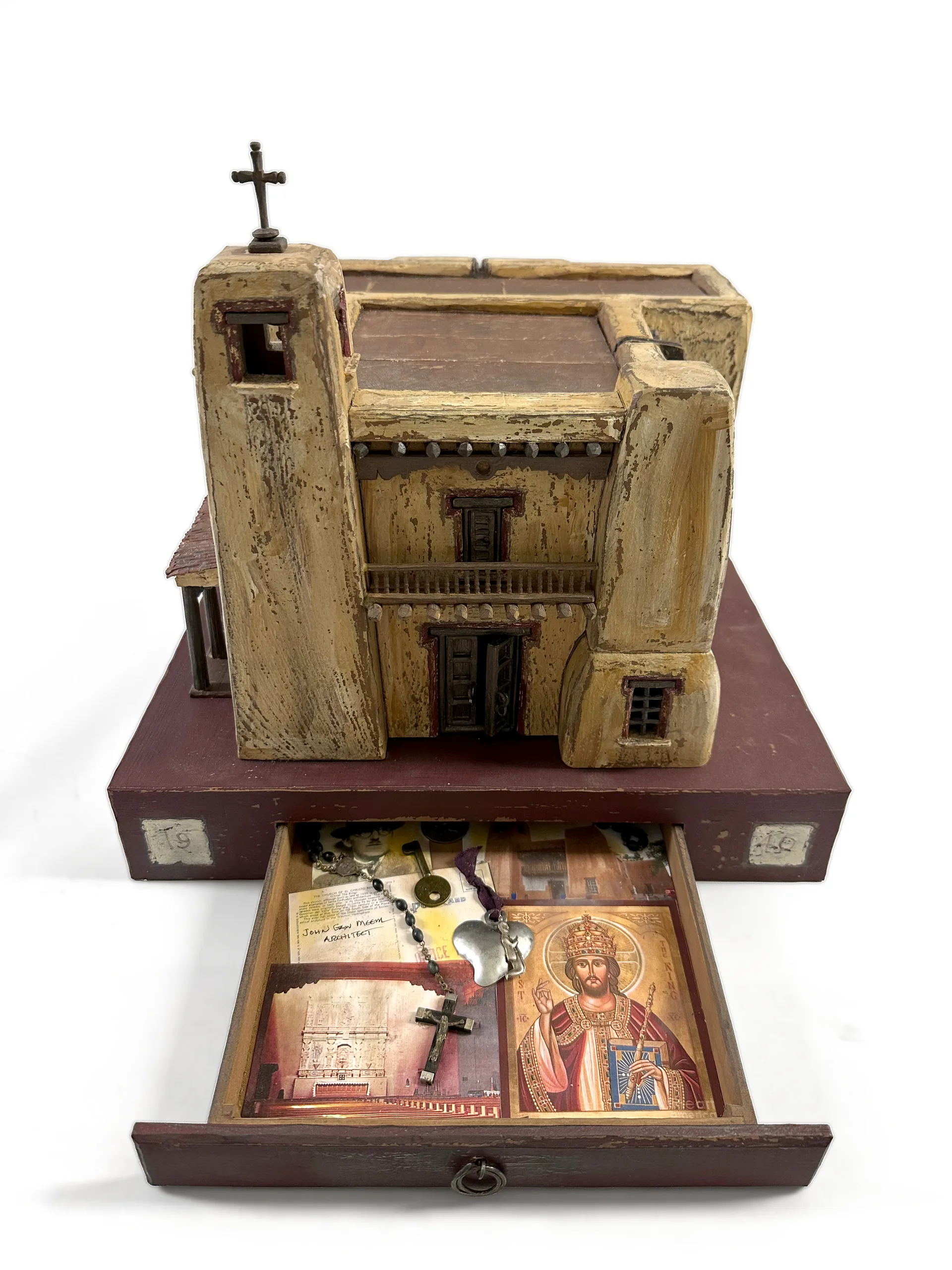 Cristo Rey Church sculpture with the base drawer open, revealing PJ Cardinale’s collage of devotional images.