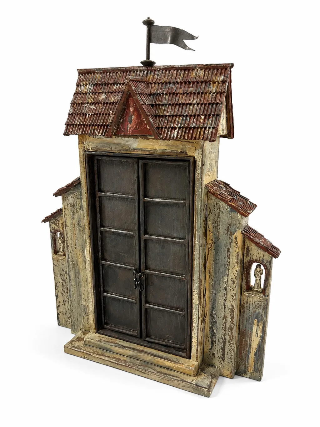 The Madonna Gate sculpture by Roberto Cardinale, a medieval city gate with a tiled roof and pennant, its doors closed.